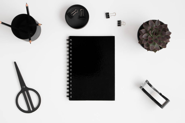 Вид зверху чорний макет ноутбука з аксесуарами робочого простору на білому столі
. - Фото, зображення