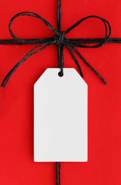 White gift tag mockup on a red christmas gift. - Photo, Image