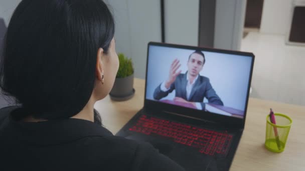 Yakın plan genç kadın dizüstü bilgisayarında konferans videosu çekiyor ve kahve içiyor. İş kadını evde dizüstü bilgisayarla internet üzerinden konferans görüşmesi yapıyor. Omuz üstü bilgisayar ekran görüntüsü. - Video, Çekim