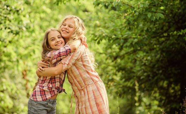 Girls children best friends hug. Sisterhood love and support. Happy childhood. Hug and love concept. Kids happy together nature background. True friendship. Girls smiling happy faces hug each other - Foto, afbeelding