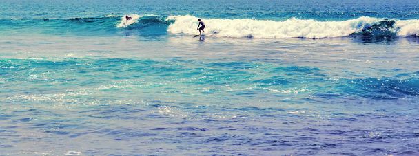 Surfer deska surfingowa Surfing stojący ocean fala Bodyboarding sporty wodne. Bali Surf Zone Surfer jazda na fali - Zdjęcie, obraz