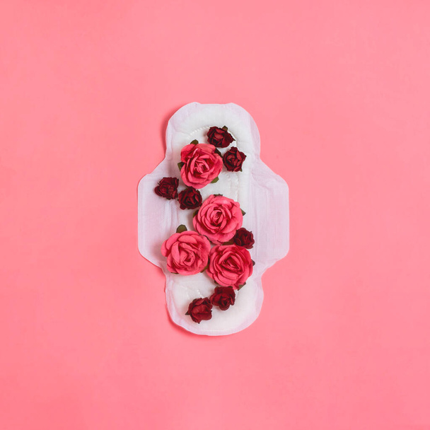 White sanitary pad with red and pink flowers on it, woman health or body positive concept - Foto, Imagem