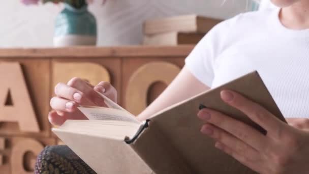 Close-Up Of A Woman's Hand Turning The Page Of A Book, A Girl Sitting In A Bright Room And Reading - Filmagem, Vídeo