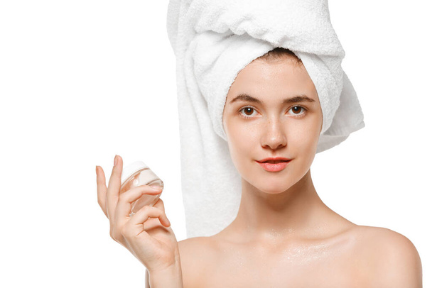 Beauty Day. Woman wearing towel doing her daily skincare routine isolated on white studio background - 写真・画像