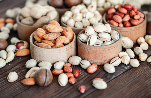Assorted nuts for a backgroundAlmond, walnut,cashew, pistachios, hazelnuts, peanuts, MacadamiaCollection of different varieties of nuts. Composition with dried fruitsHealthy food. Organic. - Photo, Image