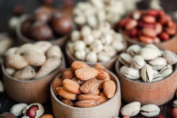 Assorted nuts for a backgroundAlmond, walnut,cashew, pistachios, hazelnuts, peanuts, MacadamiaCollection of different varieties of nuts. Composition with dried fruitsHealthy food. Organic. - Foto, afbeelding