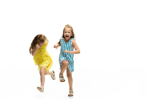 Happy little caucasian girls jumping and running isolated on white background - Foto, Bild