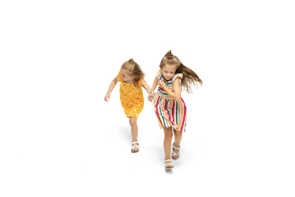 Happy little caucasian girls jumping and running isolated on white background - Foto, Bild