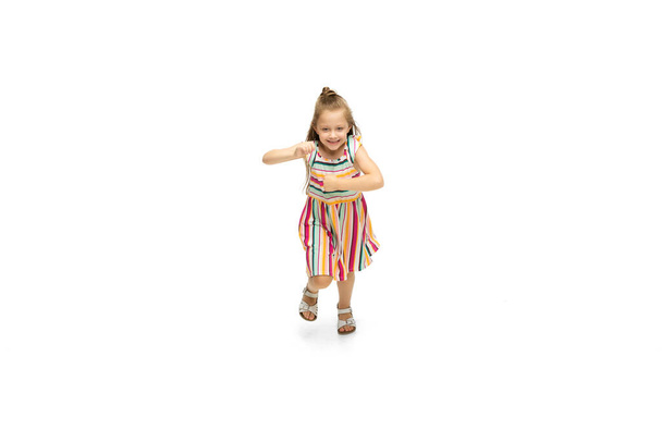 Happy little caucasian girl jumping and running isolated on white background - Foto, afbeelding