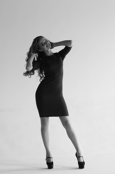 όμορφη γυναίκα με μακριά μαλλιά στο φόρεμα και ψηλά τακούνια ποζάρουν απομονωμένη σε λευκό φόντο στούντιο  - Φωτογραφία, εικόνα