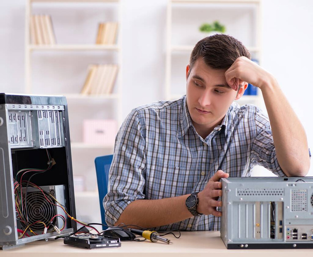 Молодой техник ремонта компьютеров в мастерской - Фото, изображение