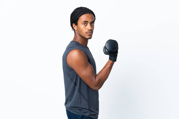 Jonge Afro-Amerikaanse man met vlechten geïsoleerd op paarse achtergrond waardoor gewichtheffen - Foto, afbeelding