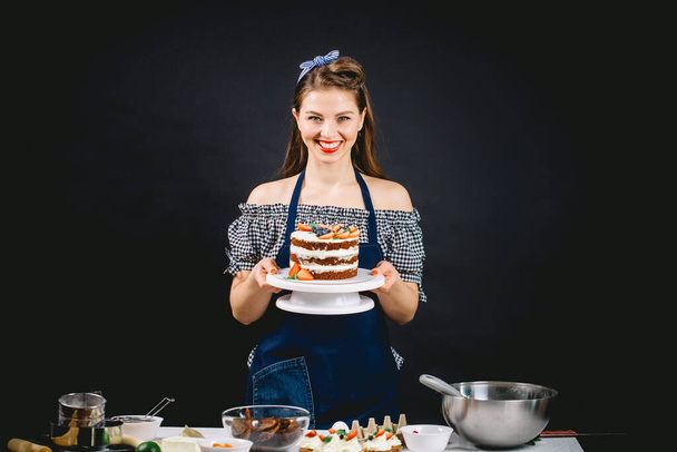 Pin-up styled woman presenting cake - Fotoğraf, Görsel