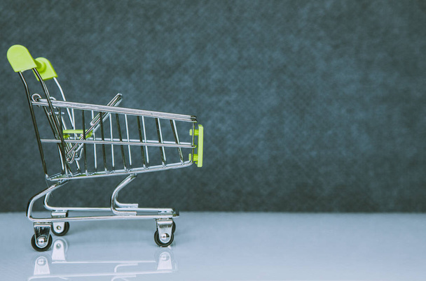 Shopping cart in green on a blurred background. Close-up. Shopping trip concept. - Φωτογραφία, εικόνα