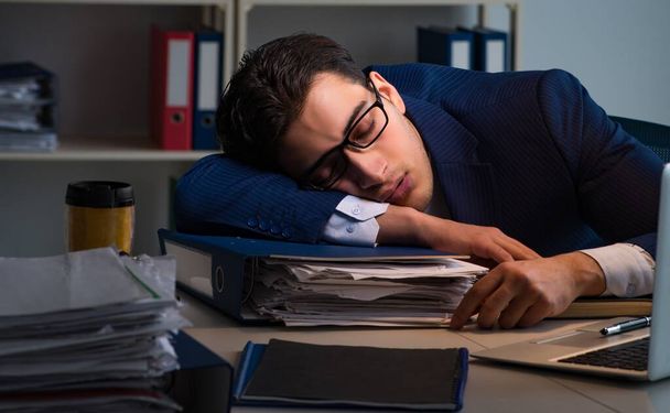 der Geschäftsmann müde und schlafend im Büro nach Überstunden - Foto, Bild