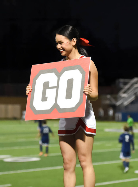 Mignon asiatique américain pom-pom girl performer à un match de football lycée - Photo, image