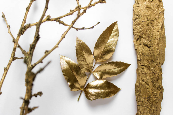 Golden decorative nature elements - golden leaf, golden wooden piece, golden dry tree branch. - Foto, imagen