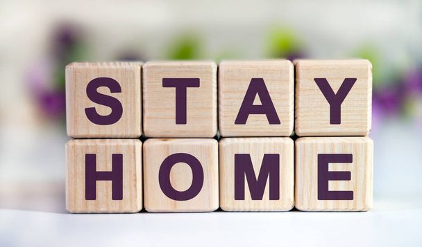 Text STAY HOME on wooden cubes with a floral background - 写真・画像