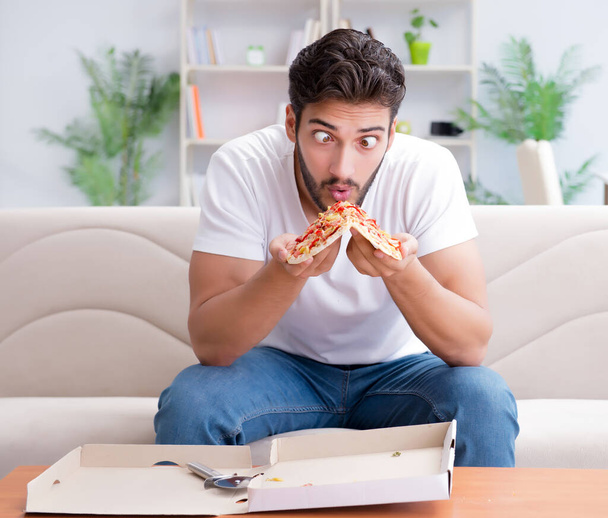 Man eating pizza having a takeaway at home relaxing resting - Fotoğraf, Görsel