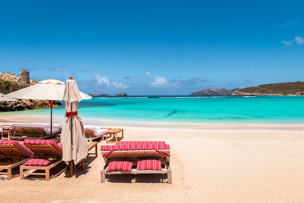 Καρέκλες παραλίας και ομπρέλα στην τροπική παραλία. Καλοκαιρινές διακοπές και χαλάρωση. - Φωτογραφία, εικόνα