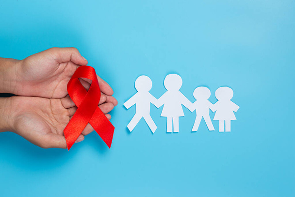 Frau hält rote Schleife mit HIV-Aufklärungskonzept Welt-AIDS-Tag und Welt-Sexualgesundheitstag. - Foto, Bild