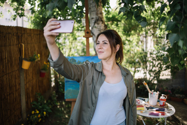 Beautiful woman taking selfie in outdoor studio - Фото, зображення