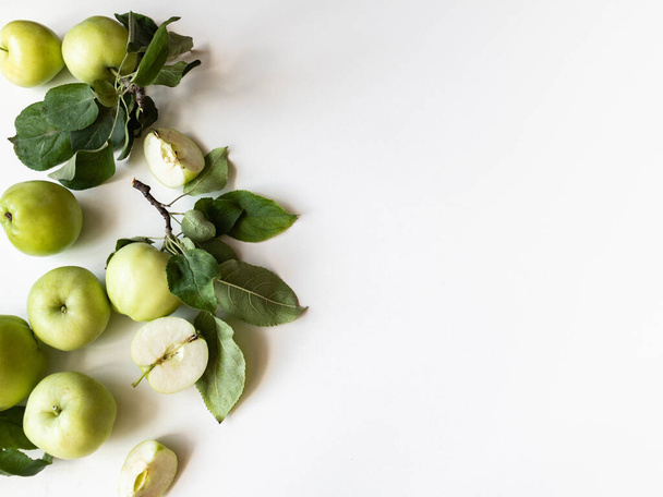 Σύνθεση πράσινων μήλων και φύλλων σε λευκό φόντο. Ταπετσαρία των φρούτων. Κάτοψη, επίπεδη lay. - Φωτογραφία, εικόνα