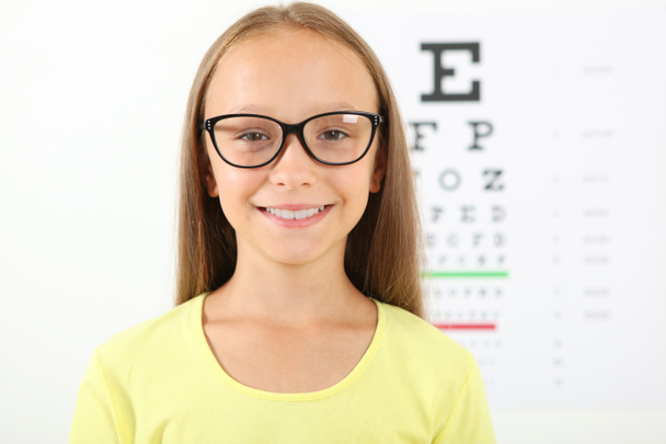 Cute little girl checks eyesight with an ophthalmologist. eyesight test - Photo, Image