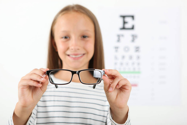 Cute little girl checks eyesight with an ophthalmologist. eyesight test - Fotografie, Obrázek