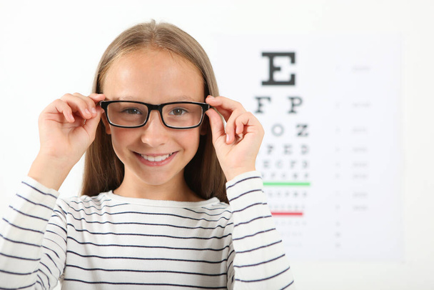 Cute little girl checks eyesight with an ophthalmologist. eyesight test - Photo, Image