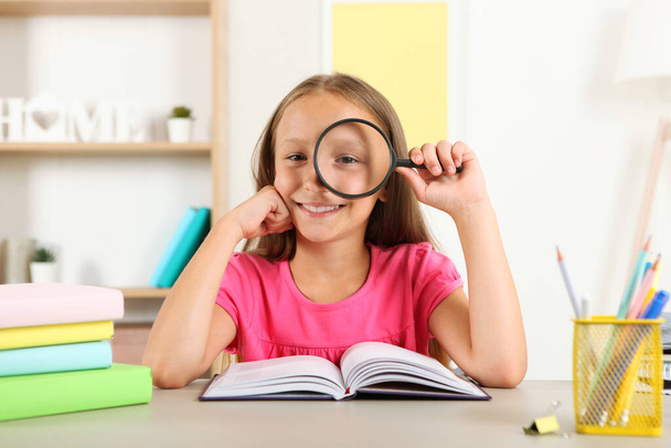 Roztomilá holčička s chabým zrakem čte s lupou - Fotografie, Obrázek