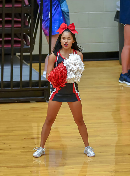 Cute Asian American Cheerleader realizando em um jogo do ensino médio
 - Foto, Imagem