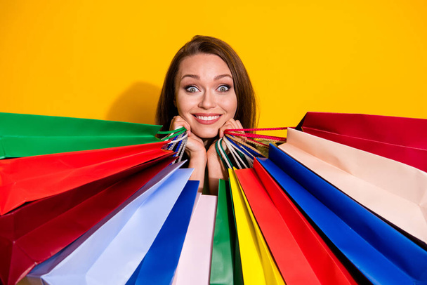 Photo of charming funny pretty lady good mood hold many shopping bags cool sales addicted shopaholic wear green sweatshirt isolated vivid bright yellow color background - Foto, imagen
