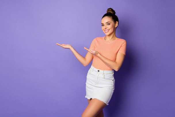 Portrait of positive cheerful girl promoter hold hand present ads promo suggest select choose decide wear good look clothes isolated over bright color background - 写真・画像