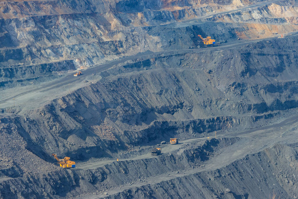 Величезний залізний рудний кар'єр з робочими сміттєвозами та екскаваторами
 - Фото, зображення