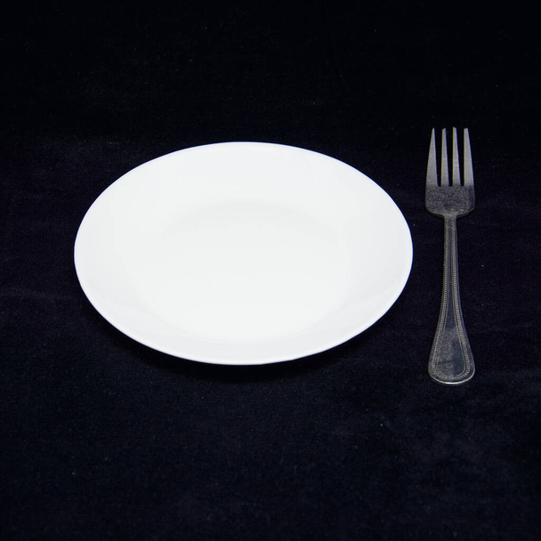 White plate with cutlery on black background - Photo, Image