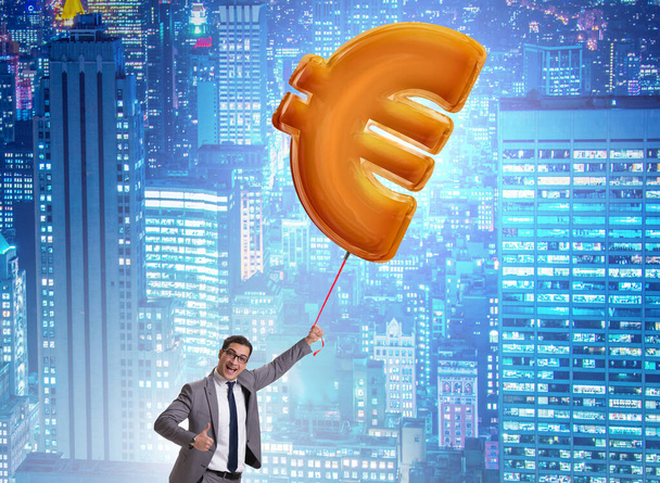 O homem de negócios que voa no balão inflável do sinal do euro - Foto, Imagem