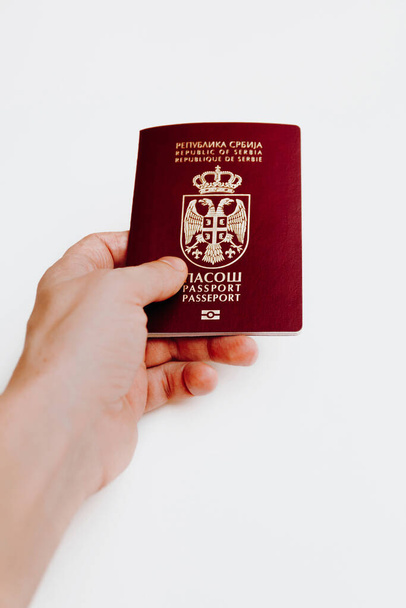 Hand hält serbischen biometrischen Pass, isoliert auf weißem Hintergrund - Foto, Bild
