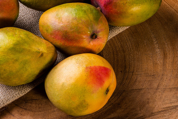 Mango. Some mangos together on wooden background. - Photo, Image