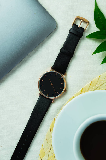 Closeup minimal fashion wristwatch for unisex on white background with flowers and computer - 写真・画像