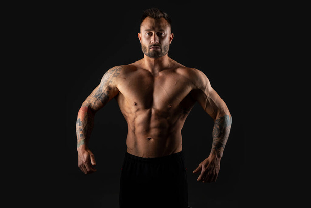 Strong man. Bodybuilder on black background. - Fotografie, Obrázek