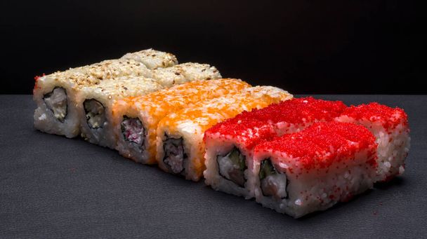 Japanese cuisine, rice rolls of different colors on a black background. - Photo, Image