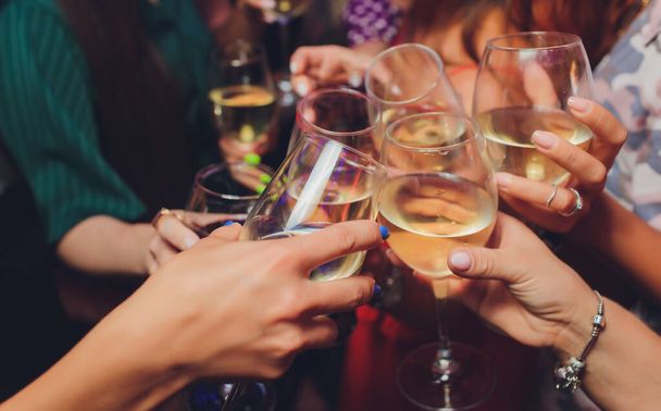 Close up shot of group of people clinking glasses with wine or champagne in front of bokeh background. older people hands. - Φωτογραφία, εικόνα