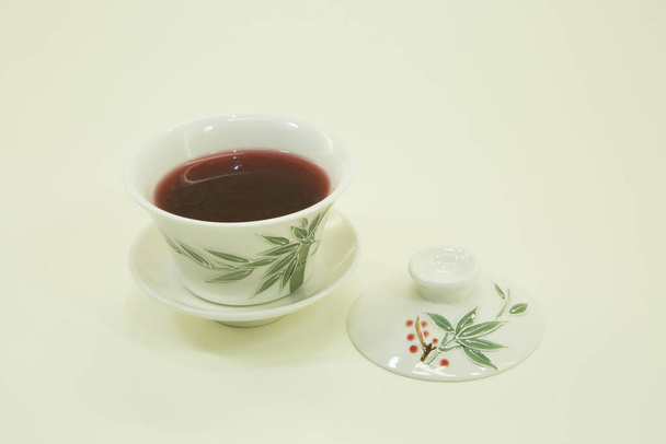 Египетский чай. Чай гибискус. Чай гибискус в красивой традиционной восточной чашке с блюдцем. Изолированный в белой чаше на белом фоне. - Фото, изображение
