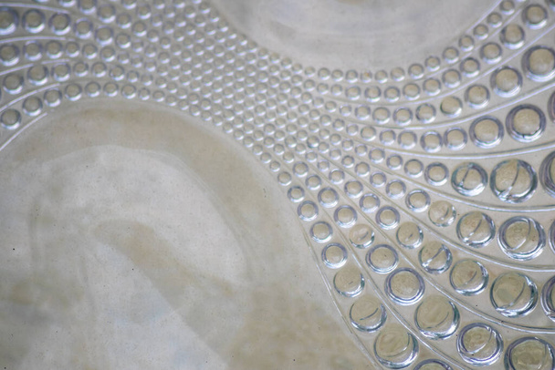 Αφηρημένο μοτίβο κύκλου σε ένα γυάλινο τούβλο ως φόντο γυαλί δείχνει ένα συμμετρικό και κομψό σχεδιασμό στη διαφάνεια, όπως τα κύματα και άπταιστα σχεδιασμό στο γυαλί - Φωτογραφία, εικόνα