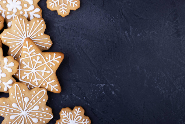 gingerbread snowflakes on a black background, top view. new year gingerbread background with space for text - Photo, image