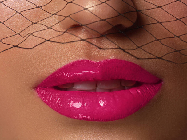 Cosmetics, makeup and trends. Bright lip gloss and lipstick on lips. Closeup of beautiful female mouth with pink lip makeup. Beautiful part of female face. Perfect clean skin in natural light - Foto, Imagem