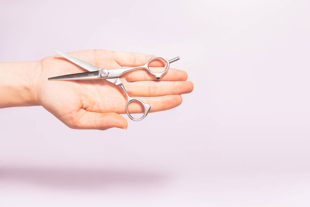 Had holding hairdresser tools scissors under trendy color background with copy space and soft light. Stylish Professional Barber Scissors, Hairdresser salon concept, Haircut accessories. - Photo, Image