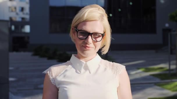 Confident blonde in a white shirt and glasses goes and reads the message and then looks at the camera.Successful Woman. - Footage, Video