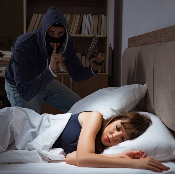 Ladrón irrumpiendo en casa por la noche en el dormitorio con wo dormir - Foto, imagen